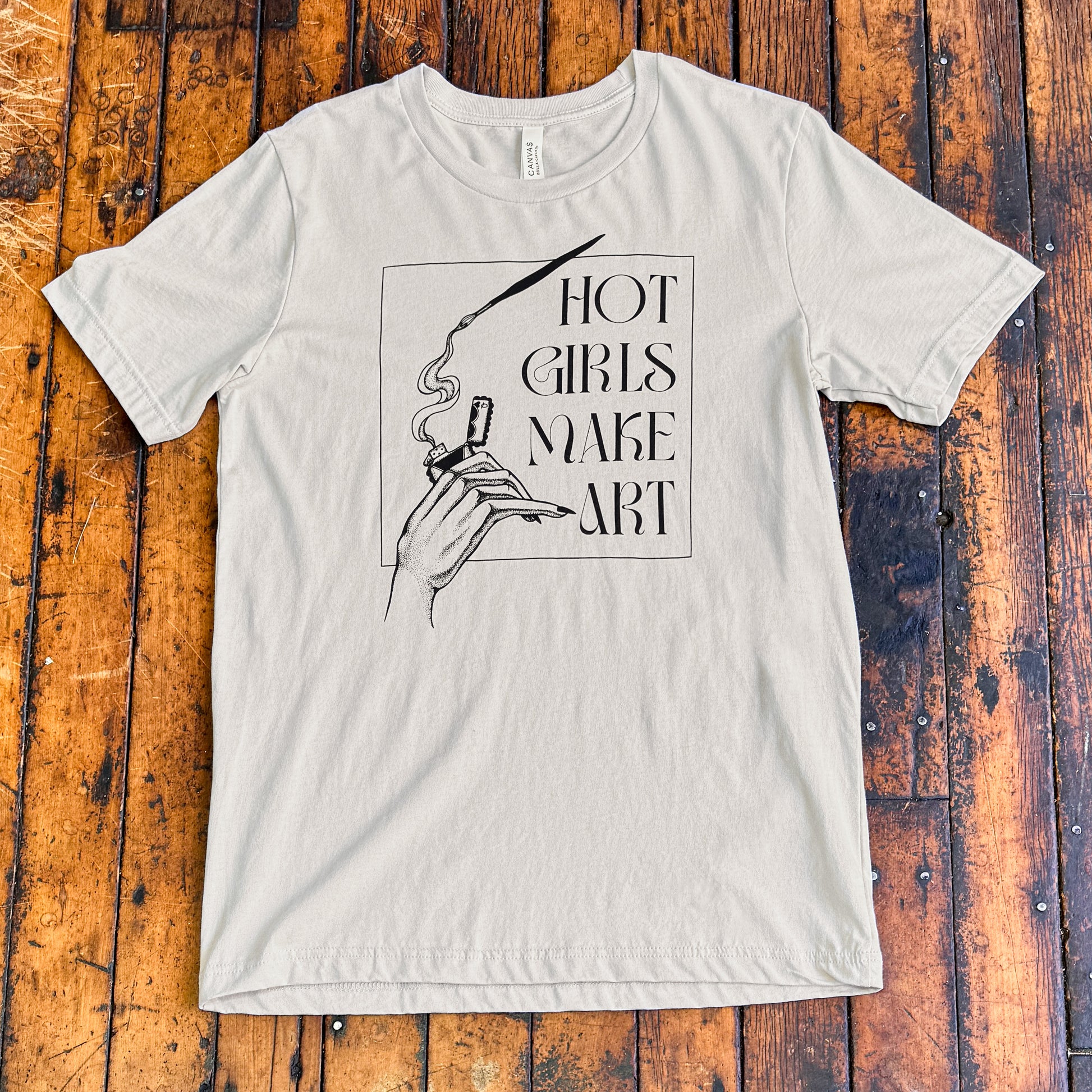 grey tee shirt that says hot girls make art on the front with a hand holding a zippo lighter and smoke paint coming out of a paintbrush