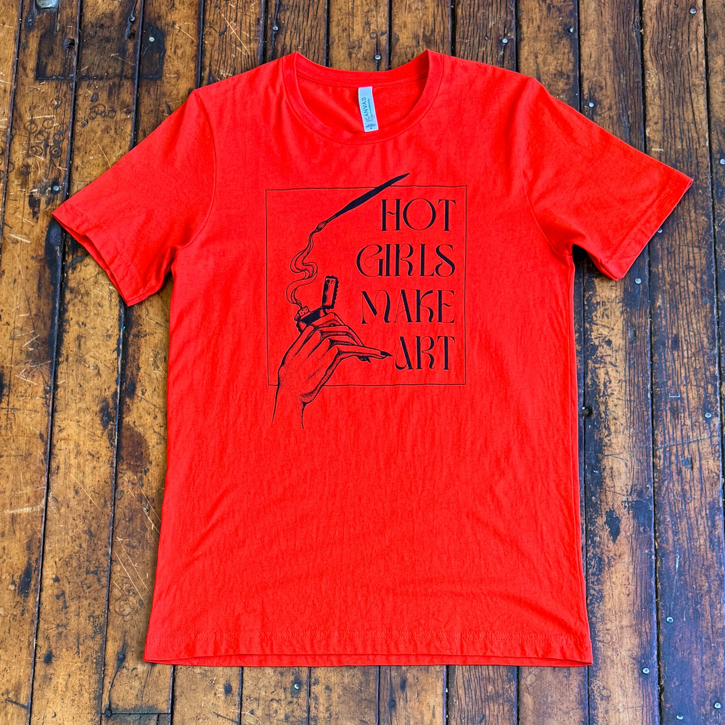 red tee shirt that says hot girls make art on the front with a hand holding a zippo lighter and smoke paint coming out of a paintbrush